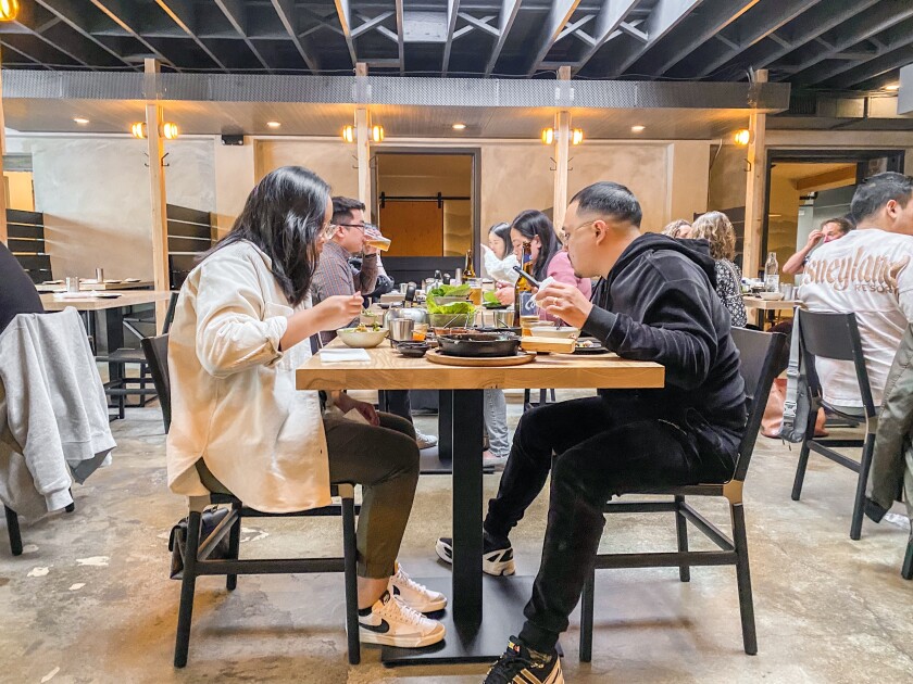 Customers of San Ho Wan seated at tables while eating their meals.