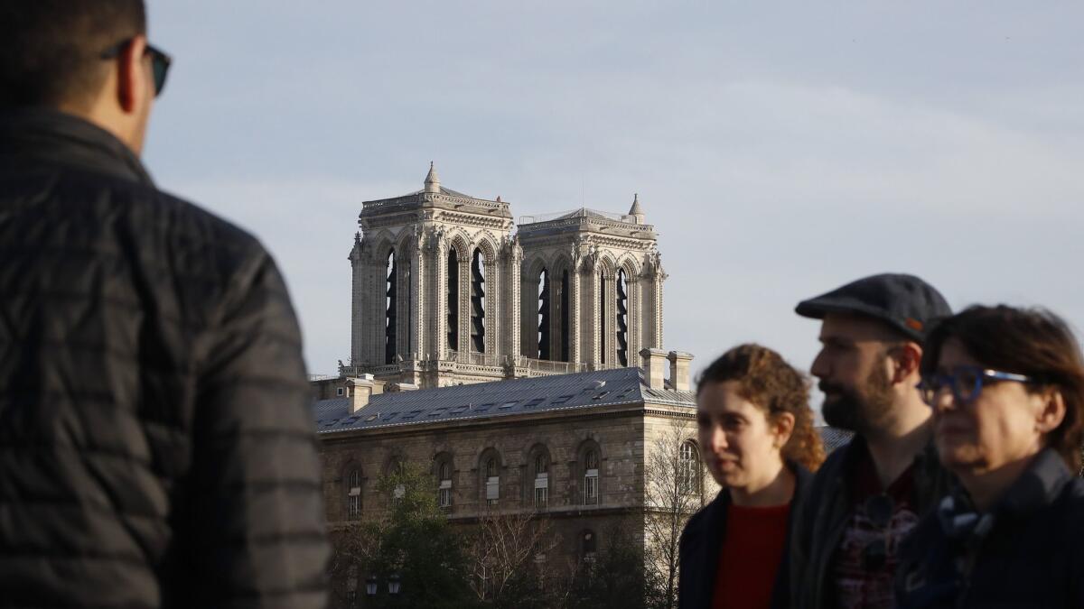 A man looks at the Notre Dame Cathedral from the Change bridge in Paris on April 17.