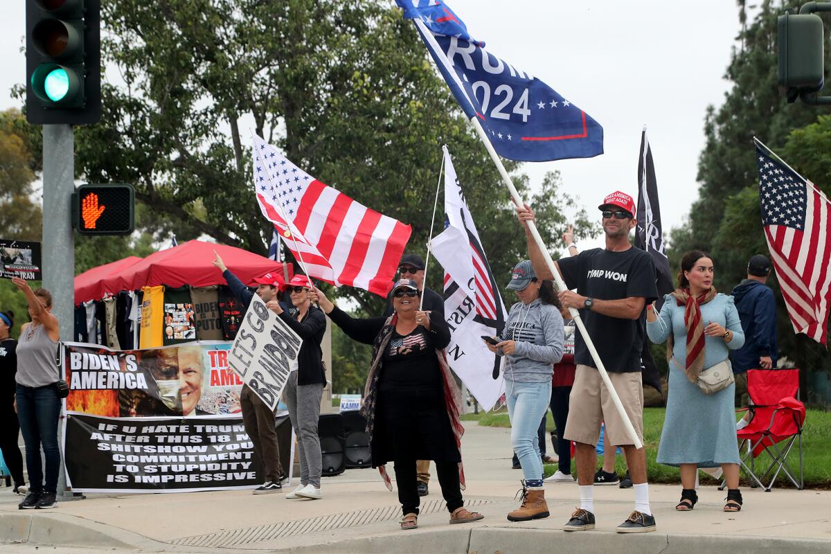 Supporters of former president Donald Trump protest at an entrance along Irvine Center Drive during President Biden's visit.