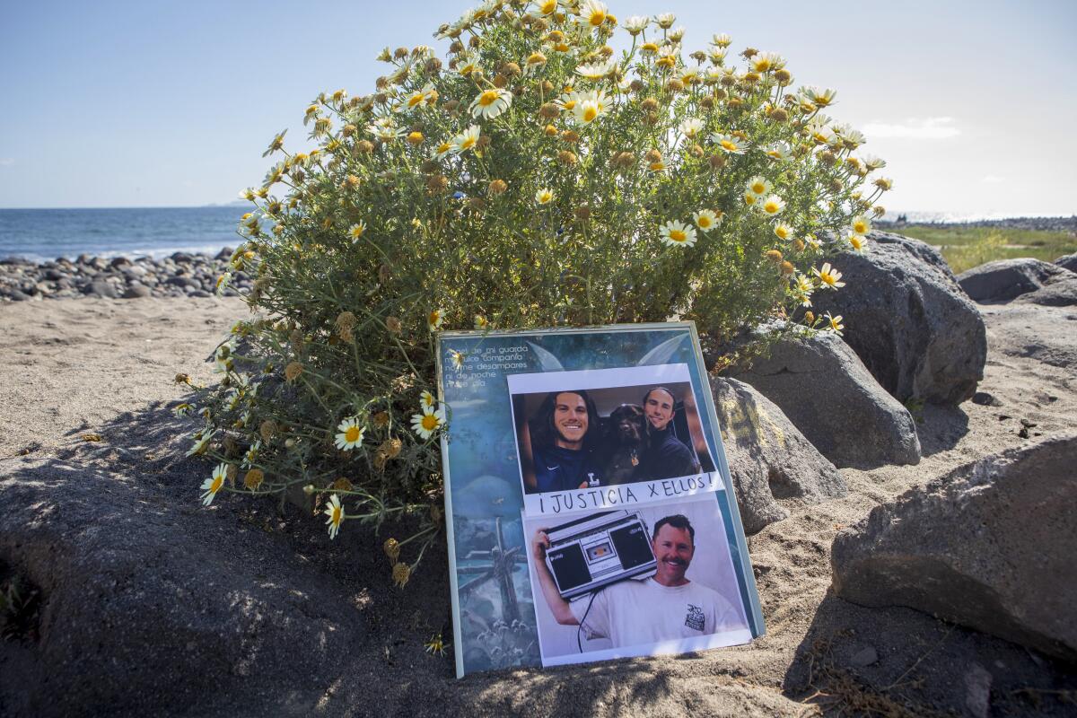 Photos of the surfers who disappeared in Mexico are seen on the beach in Ensenada, Mexico.
