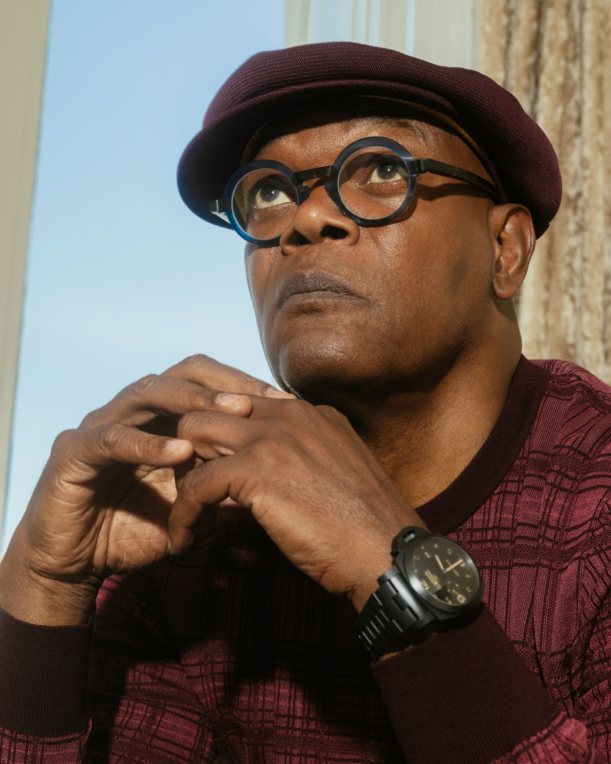 Samuel L. Jackson in a burgundy sweater and a burgundy hat.