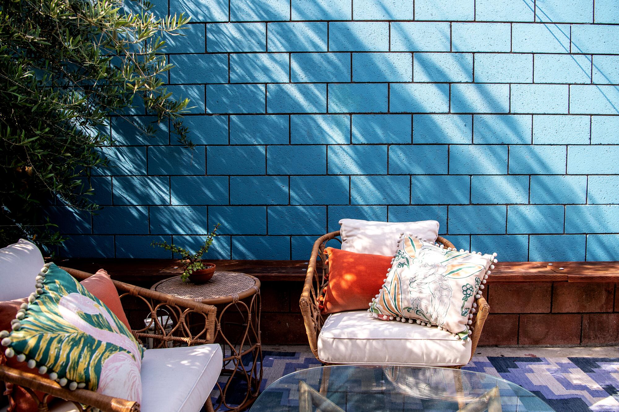 An outdoor patio and a cinder-block wall painted blue 