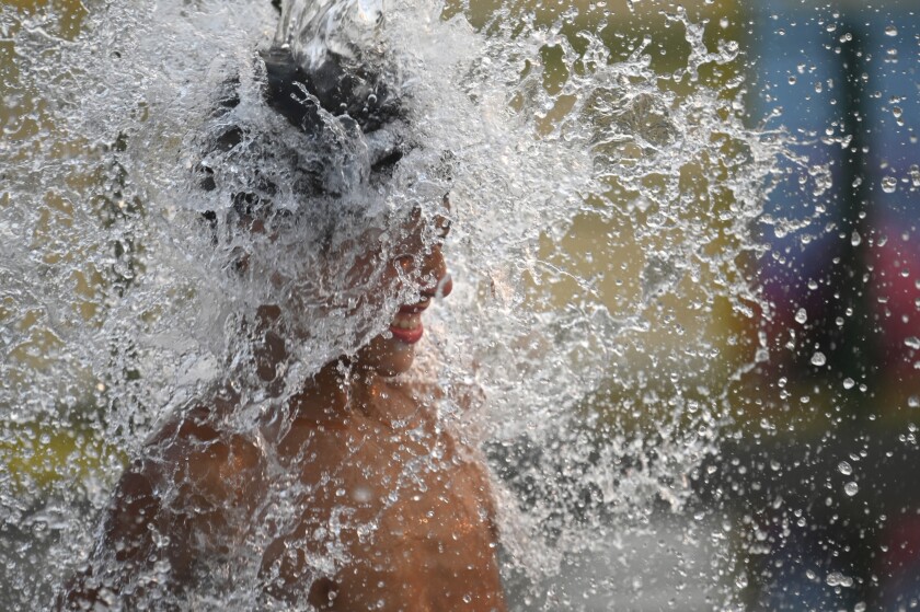 Un niño se refresca en plena ola de calor estival en Buenos Aires, Argentina, el 14 de enero de 2022. (AP Foto/Mario De Fina)