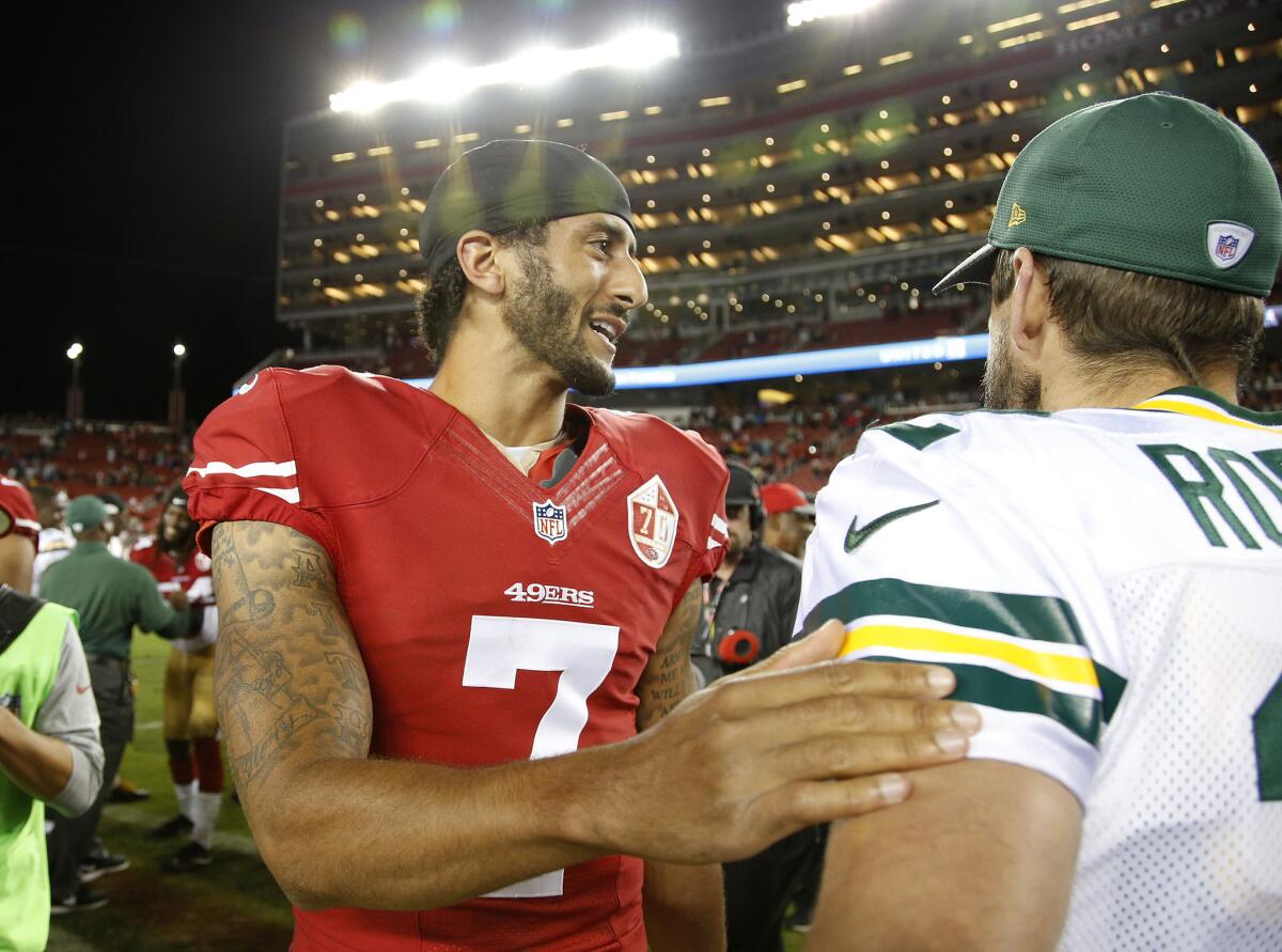 El quarterback Colin Kaepernick, de los 49ers de San Francisco, a la izquierda, saluda al quarterback de los Green Bay Packers, Aaron Rodgers, al término del partido de pretemporada de la NFL entre ambos equipos en Santa Clara, California. Green Bay ganó 21-19. (AP Foto/Tony Avelar)