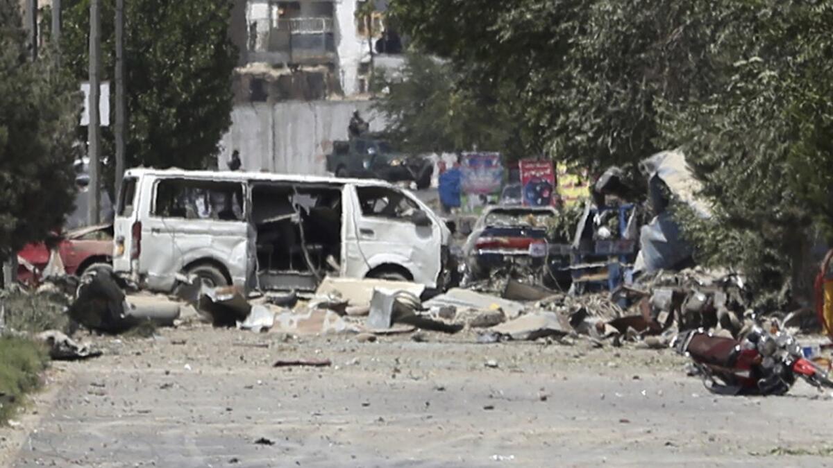 Destroyed vehicles, including a white van, sit at the site of an explosion in Kabul, Afghanistan, on Monday.