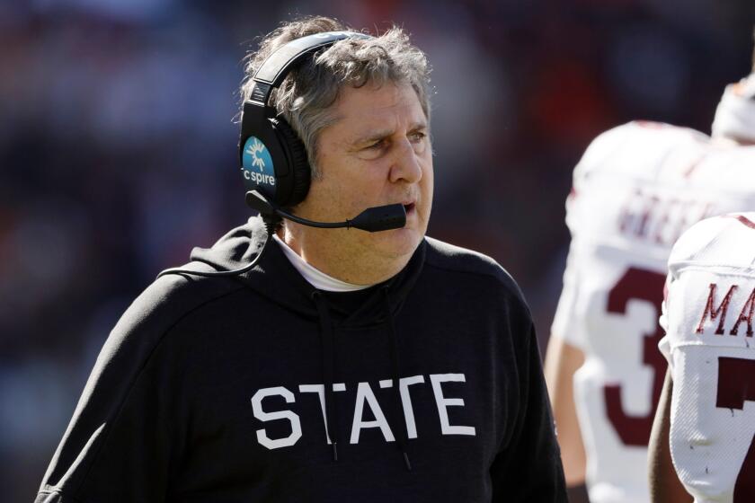 Mississippi State head coach Mike Leach talks with players during a timeout.