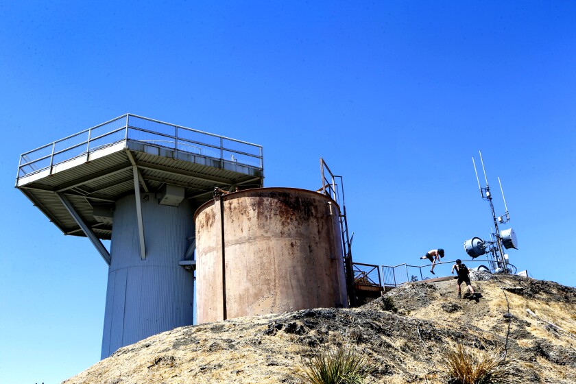 In this Wednesday, Aug. 9, 2017 photo, two men climb a hill toward the former Nike Missile Control Site LA-96, which was operational for a period of time during the Cold War, at San Vicente Mountain Park on the Santa Monica Mountains in Los Angeles. The Cold War years, from the 1950s through the 1980s were a time when people often felt confident to let their children play outside unsupervised while simultaneously fearing they might perish with them in a nuclear war between the United States and Soviet Union. With the collapse of the Soviet Union those fears seemed to end. With angry exchanges between North Korea and the U.S. in the news, they are back. People once again are fretting how they can stay safe. (AP Photo/Damian Dovarganes)