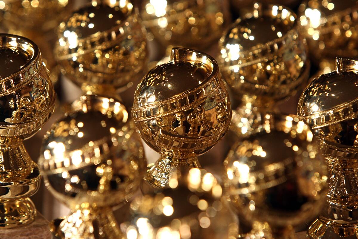 A closeup of closely packed rows of Golden Globe statuettes.