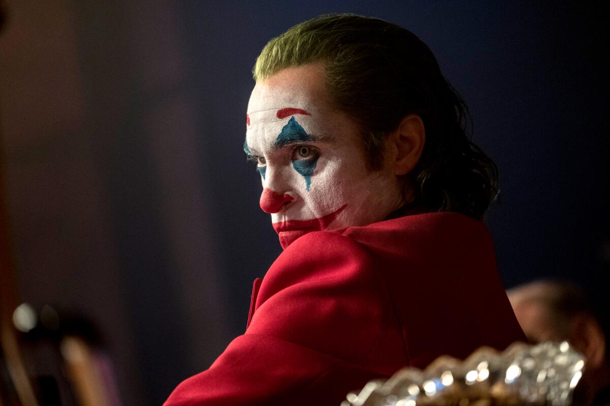 A man in clown makeup scowls.