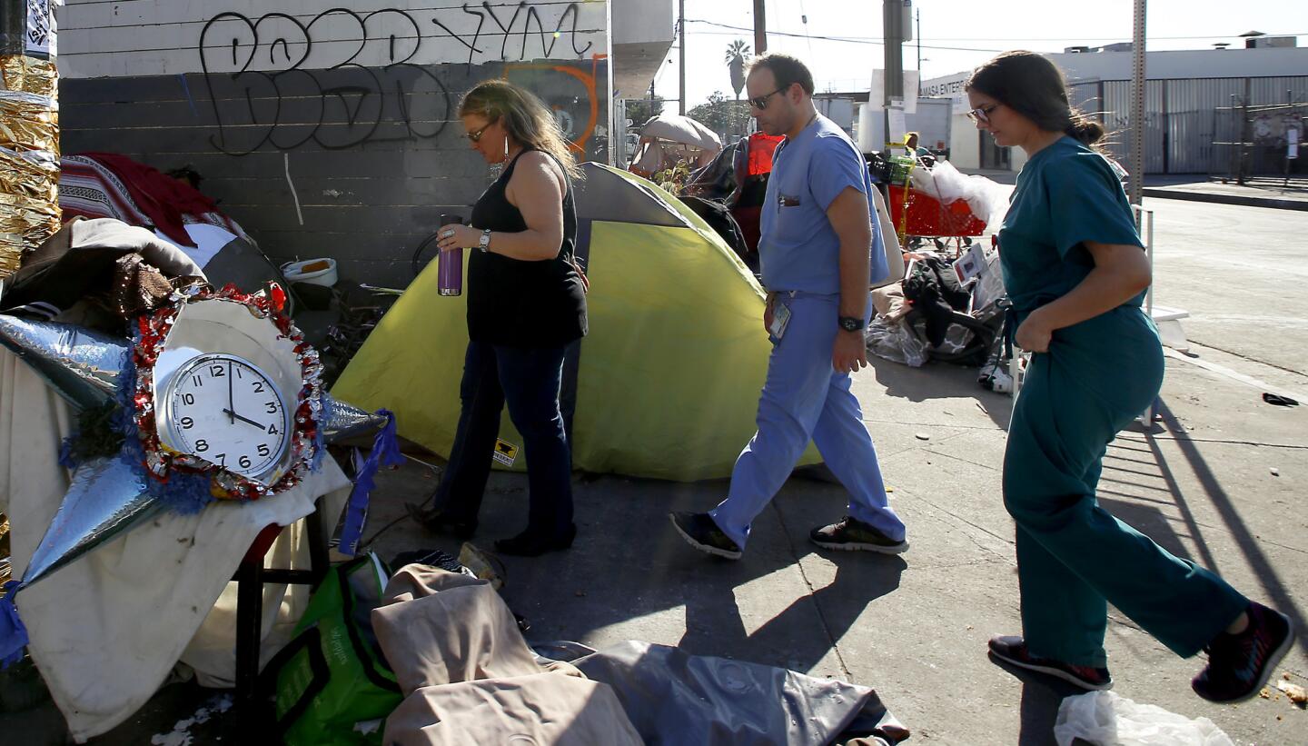 Dr. Susan Partovi, from left, and resident physicians Dr. Andrew Frerking and Dr. Lisa Altieri walk through skid row as they try to persuade some of the most mentally ill homeless people to seek psychiatric treatment.