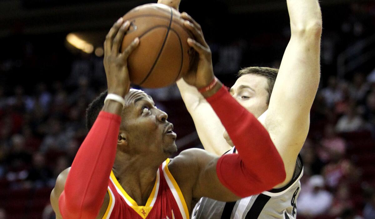 Rockets center Dwight Howard looks for a shot against Spurs center Aaron Baynes in the first half Thursday night in Houston.
