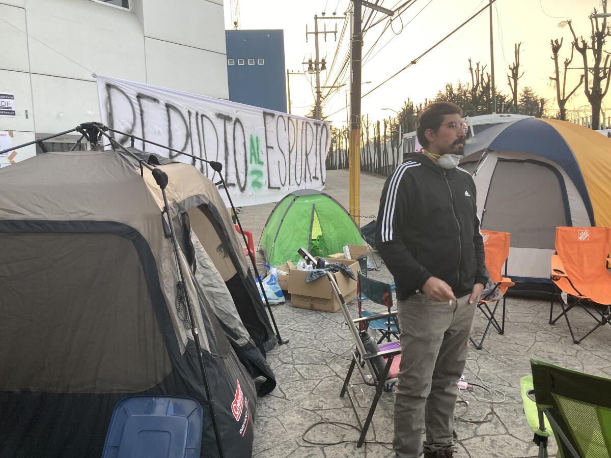 Hombre rodeado de tiendas de campaña