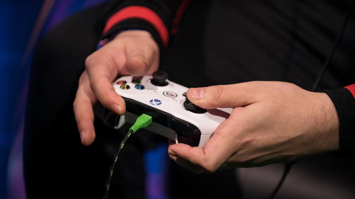 A gamer holds an Xbox controller.