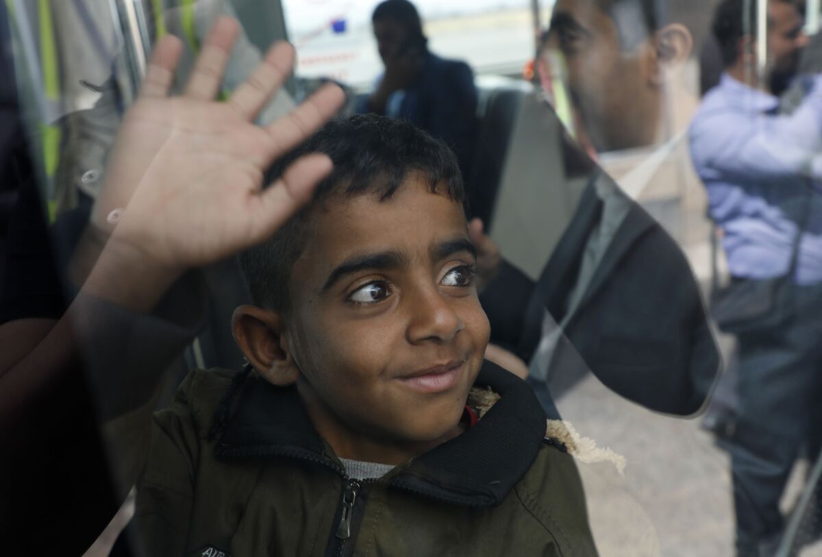 A Yemeni boy waves from inside a bus before boarding a United Nations plane at Sanaa International airport, Yemen, Monday, Feb. 3, 2020. The United Nations medical relief flight carrying patients from Yemen's rebel-held capital was the first in over three years. The U.N. said eight patients and their families were flown to Egypt and Jordan to receive “life-saving specialized care not available in Yemen." (AP Photo/Hani Mohammed)