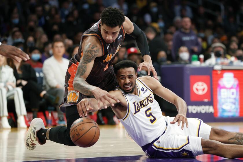 Los Angeles Lakers guard Talen Horton-Tucker (5) and Orlando Magic forward Chuma Okeke (3) fight for the ball during the first half of an NBA basketball game in Los Angeles, Sunday, Dec. 12, 2021. (AP Photo/Ringo H.W. Chiu)