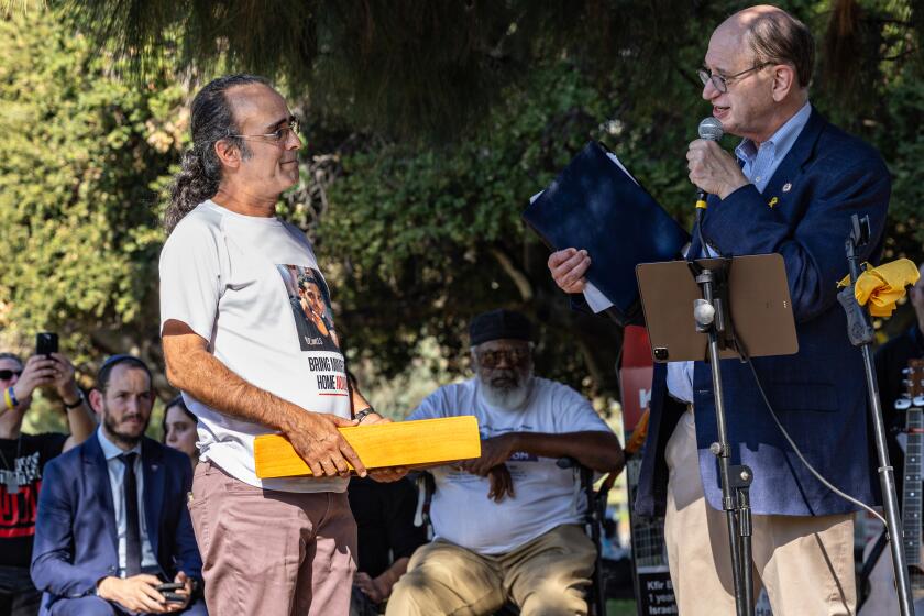 Encino, CA - October 06: Rep. Brad Sherman, D-Sherman Oaks presents Yehuda Cohen, father of Israeli hostage Nimrod Cohen with a flag that flew at the Capitol at the Rally in the Valley in support of Israeli hostages held by Hamas in Gaza on Sunday, Oct. 6, 2024 in Encino, CA. (Jason Armond / Los Angeles Times)