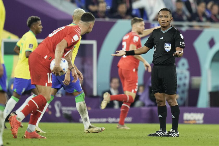 Referee Ivan Barton of Salvador, right, gestures during the World Cup group G soccer match between Brazil and Switzerland at the Stadium 974 in Doha, Qatar, Monday, Nov. 28, 2022. (AP Photo/Hassan Ammar)