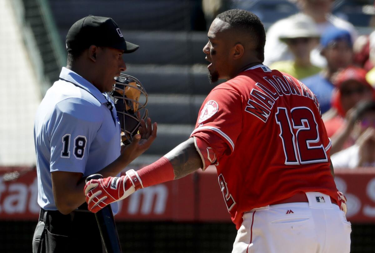 Los Angeles Angels' Martin Maldonado, right, argues with home plate umpire Ramon De Jesus during the eighth inning of a baseball game against the Toronto Blue Jays in Anaheim, Calif., Sunday, April 23, 2017. (AP Photo/Chris Carlson)