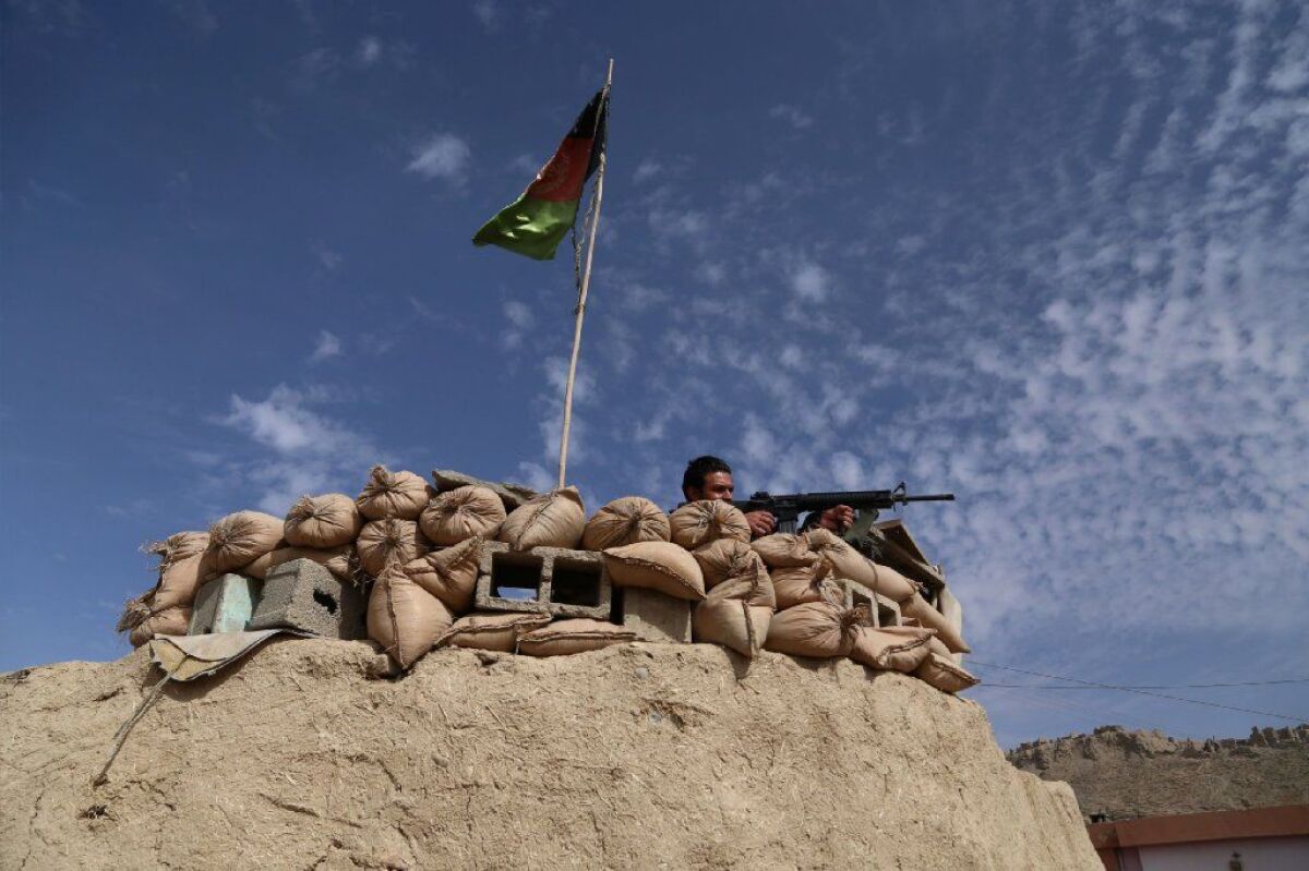 An Afghan keeps watch at a checkpoint on Highway One in Ghazni province in October.