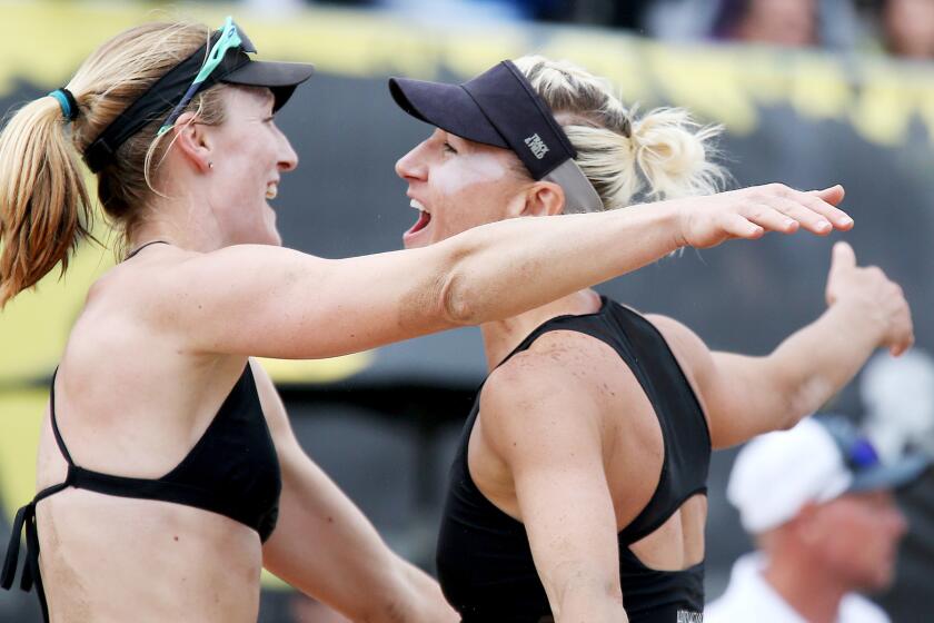 Emily Day, left, and Brittany Hochevar celebrate after beating Betsi Flint and Kelley Larsen during the AVP Huntington Beach Open women's championship match.