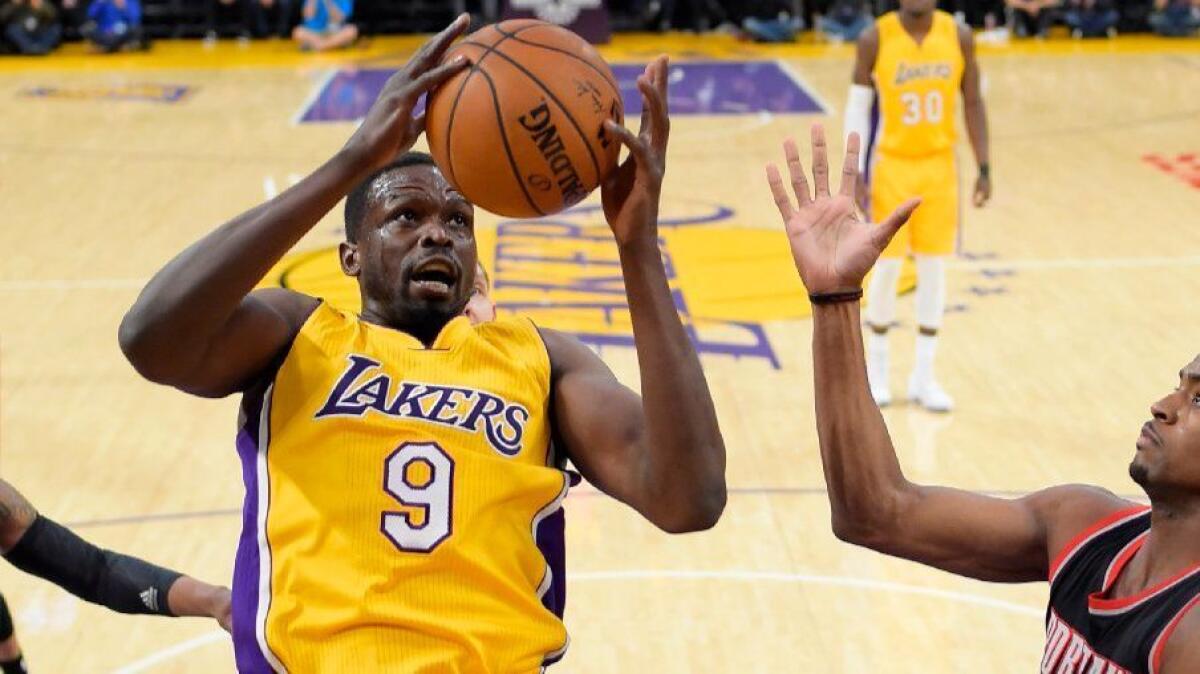 Lakers forward Luol Deng grabs a rebound in front of Trail Blazers forward Maurice Harkless during the first half of a game at Staples Center on Jan. 10.