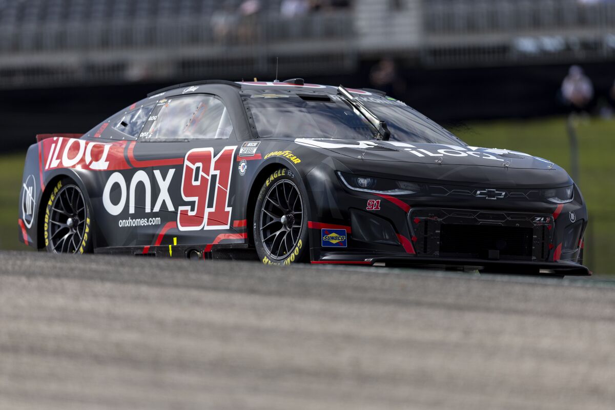 Kimi Raikkonen steers his car through Turn 1 during qualifying qualifying for the NASCAR Cup Series auto race at Circuit of the Americas, Saturday, March 25, 2023, in Austin, Texas. (AP Photo/Stephen Spillman)