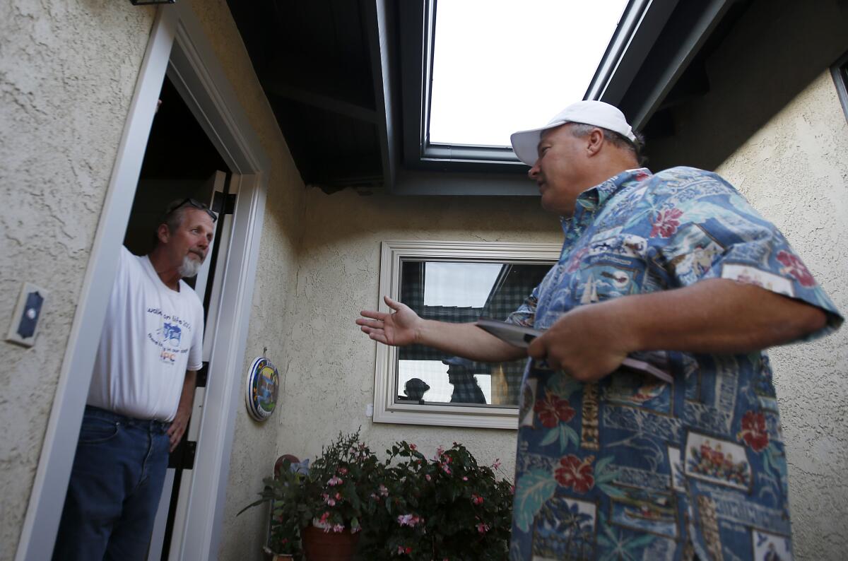 Congressional candidate Scott Baugh stands at a door, talking with a voter