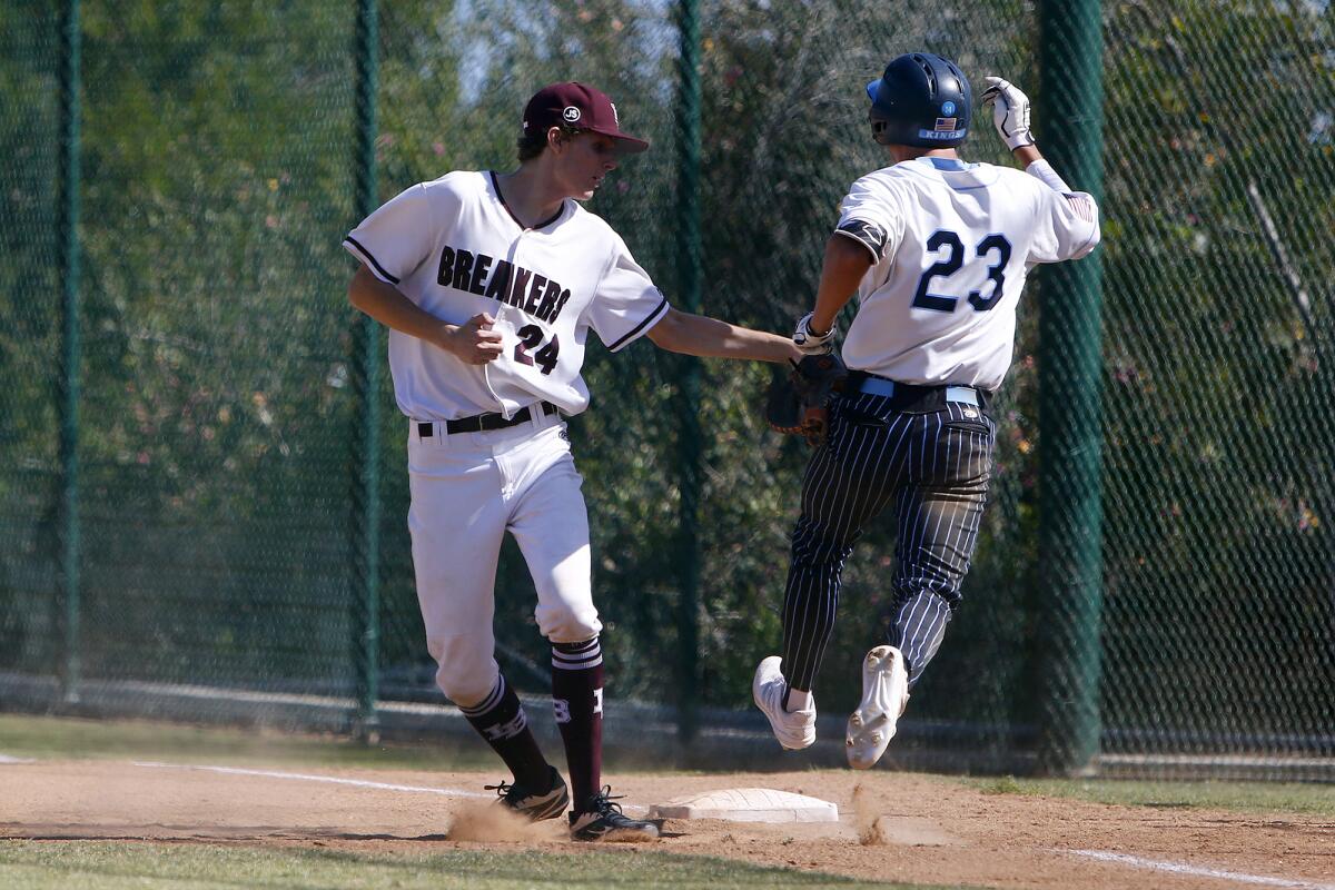 Laguna Beach's Max Burchi (24) makes the tag on Corona del Mar's Van Sidebotham (23) in a Wave League game on Wednesday.