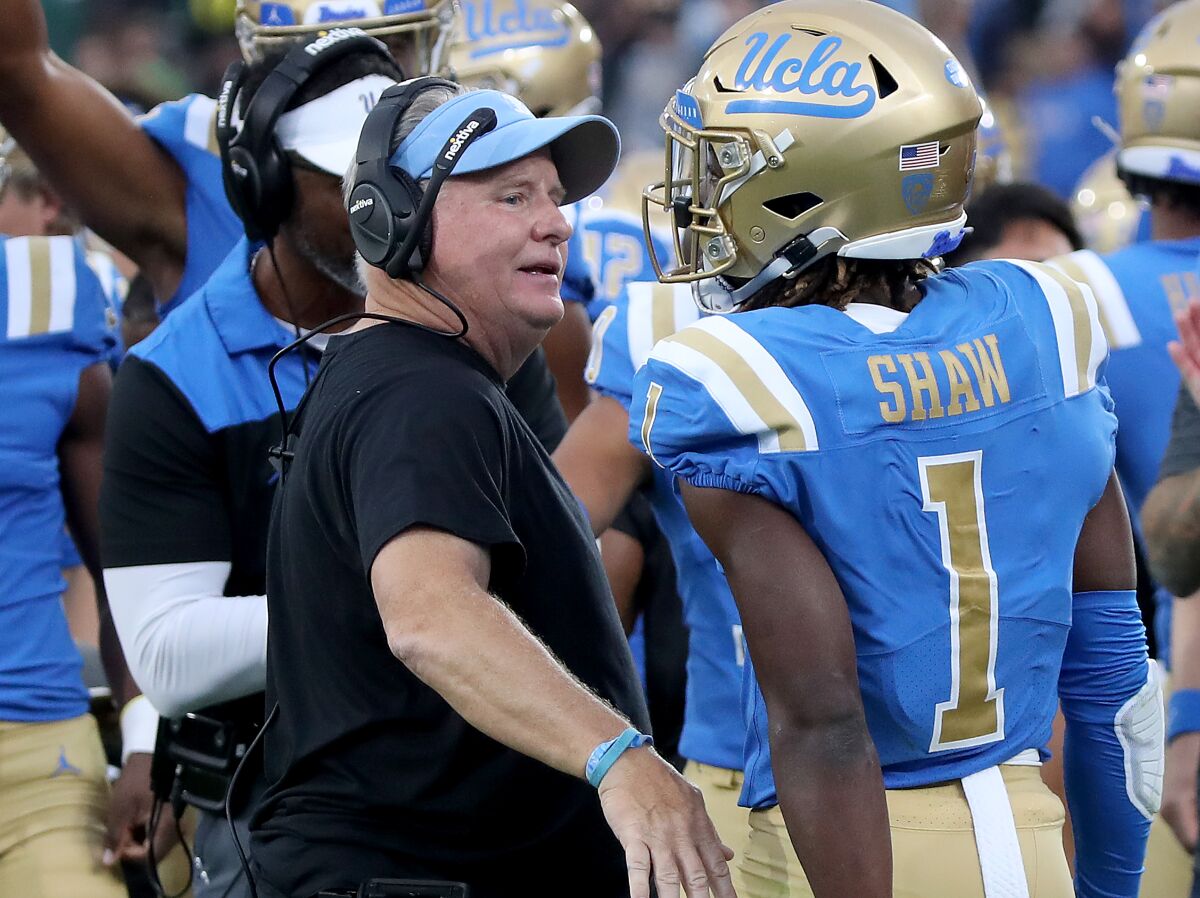UCLA defensive back Jay Shaw is congratulated by coach Chip Kelly after making an interception.