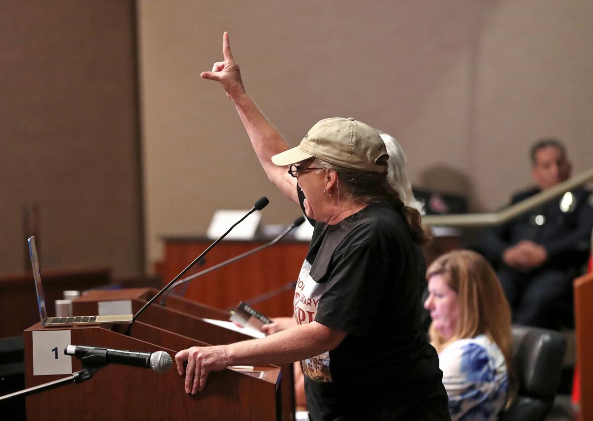 A public speaker makes emotional comments from the podium during vocal Huntington Beach City Council meeting on Tuesday.