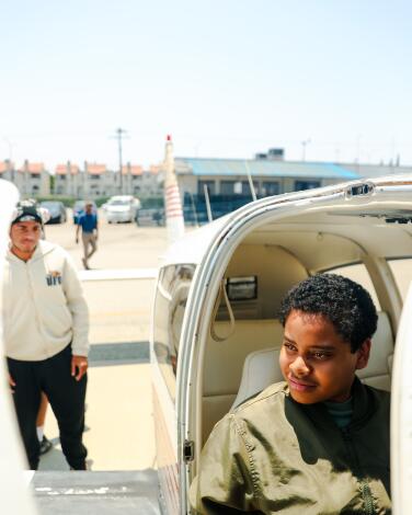 Aydin Washington smiles while seated in a helicopter