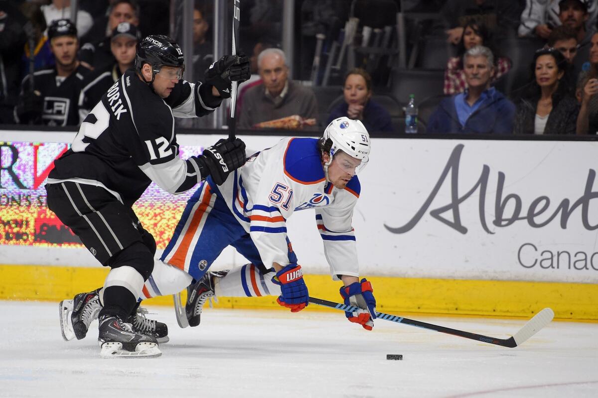 Kings right wing Marian Gaborik, left, watches as Edmonton center Anton Lander reaches for the puck.