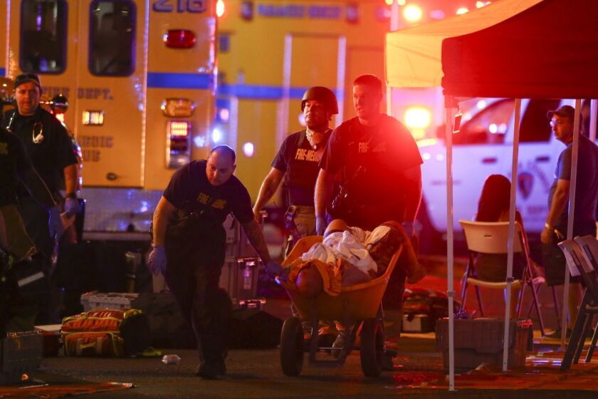 A wounded person is walked in on a wheelbarrow as Las Vegas police respond during an active shooter situation on the Las Vegas Stirp in Las Vegas Sunday, Oct. 1, 2017. Multiple victims were being transported to hospitals after a shooting late Sunday at a music festival on the Las Vegas Strip. (Chase Stevens/Las Vegas Review-Journal via AP)