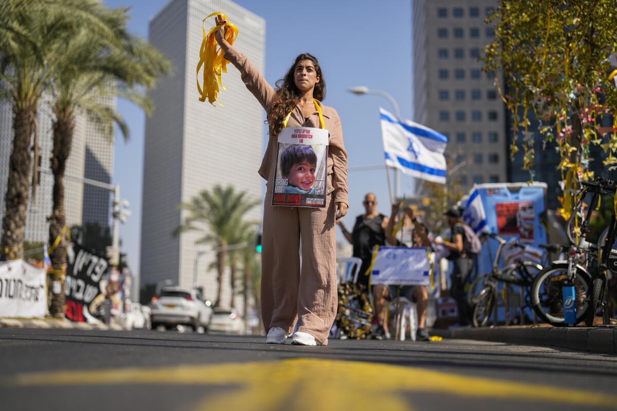 A woman holds a photo of a child who was abducted during the Hamas attack on Israel, 