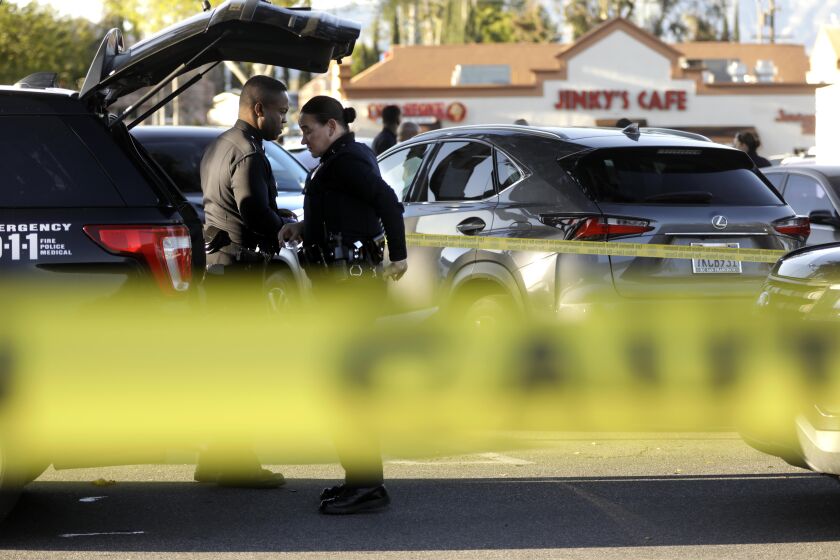 WEST HILLS, CA - APRIL 1, 2023 - Police investigate the scene of a shooting in a West Hills shopping parking lot that left one person dead and many others wounded at 6751 Fallbrook Avenue in West Hills on April 1, 2023. (Genaro Molina / Los Angeles Times)