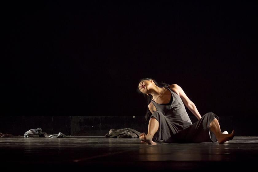 Dancer-choreographer Joyce Lien Kushner performs in a black studio.