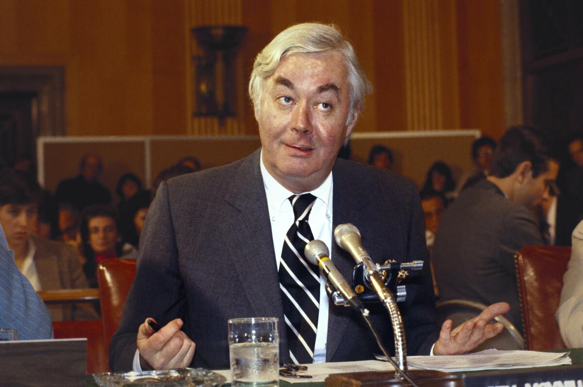 Sen. Moynihan, seated at a table in a Senate hearing room