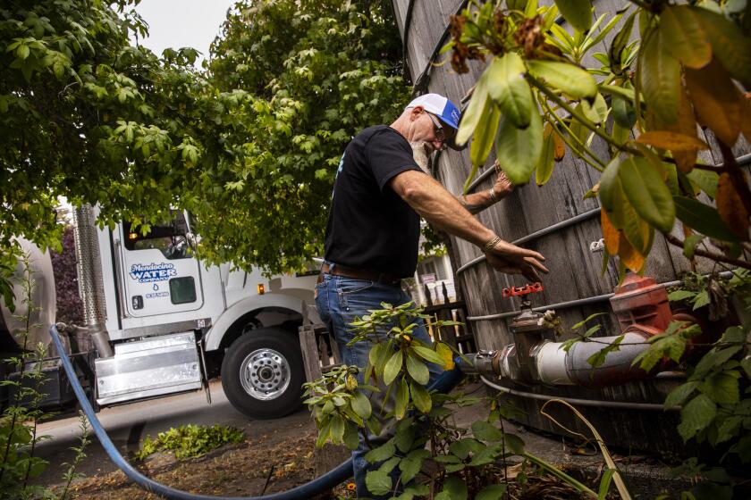 Mendocino, CA - August 10: Wayne Jones, owner of Mendocino Water Company, delivers 3,500 gallons of pottable water to the Medocino Hotel, in Mendocino, CA, Tuesday, Aug. 10, 2021. With drought gripping Mendocino County, Jones says that he and his son have been working seven days each week lately, filling water tanks and have only been slowed by having limited sources providing them water to haul. With no central system for water delivery, residents of Mendocino are relying on water wells on their properties or, if they've dried up, utlizing storage tanks and paying to have them filled by water haulers like Jones. (Jay L. Clendenin / Los Angeles Times)