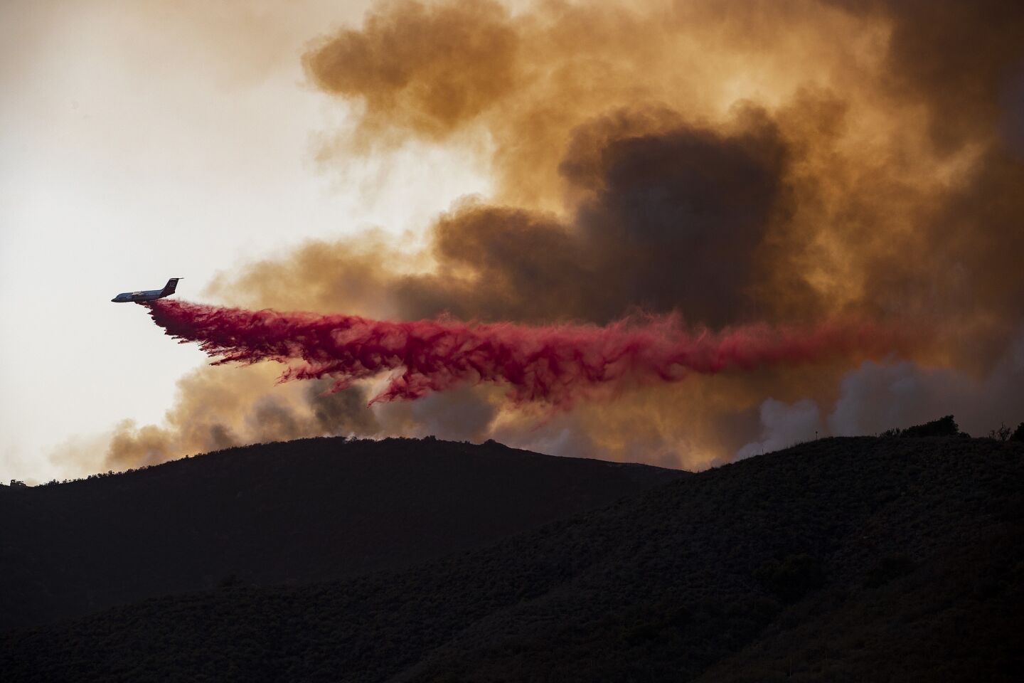 An air tanker drops fire retardant on a flare-up of the Holy fire on a mountain ridge above Lake Elsinore, Calif. Saturday.