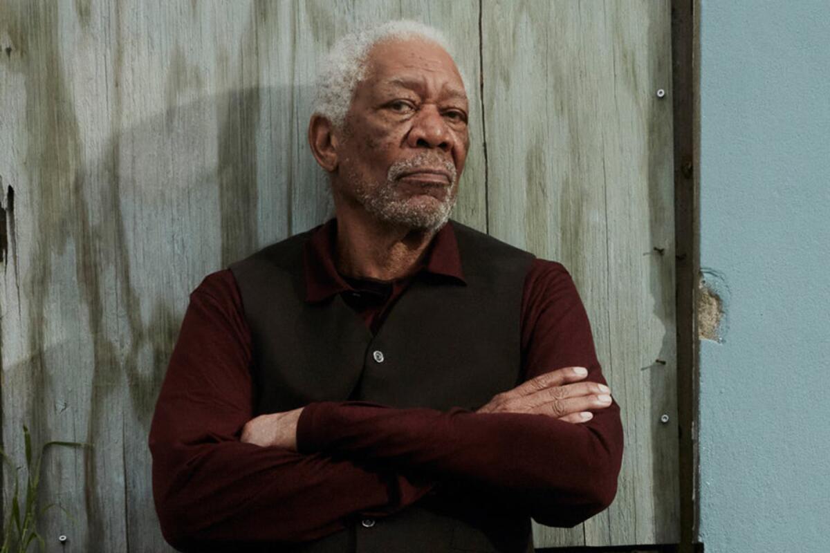 Morgan Freeman stands with his arms crossed.