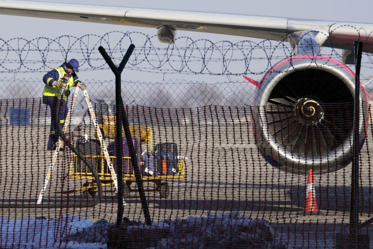 FILE - A worker fixes an Air Serbia passenger plane at Belgrade's Nikola Tesla Airport, Serbia, Monday, Jan. 17, 2022. Ukraine on Monday, April 18, 2022 rejected as baseless and false accusations made by Serbia's president that Ukraine's secret service is behind a series of hoax bomb threats against Air Serbia flights to Russia. Serbian President Aleksandar Vucic has said foreign intelligence services of Ukraine and an unidentified European Union state "are doing that." (AP Photo/Darko Vojinovic, File)