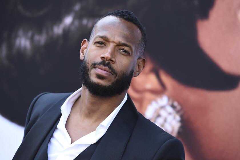 Marlon Wayans looks up with a slightly furrowed brow during a movie premiere