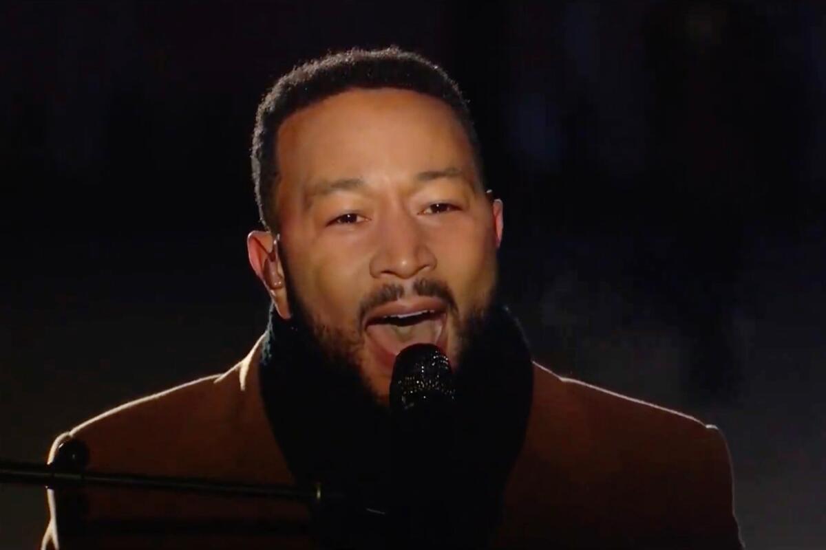 John Legend singing into a microphone.