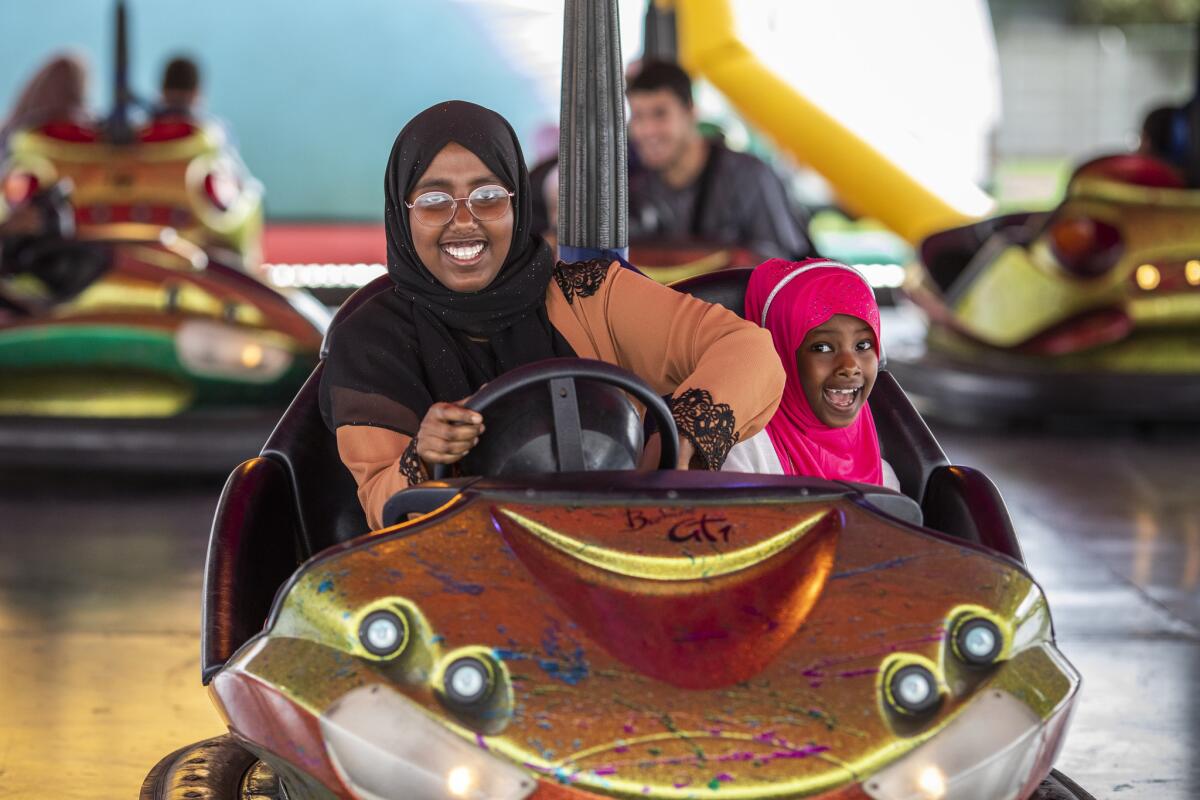 England: Salma Sulayman, 13, and sister Saabrin Sulayman, 7, enjoy a ride in bumper cars during an Eid in the Park celebration at the New River Sports ground in London.