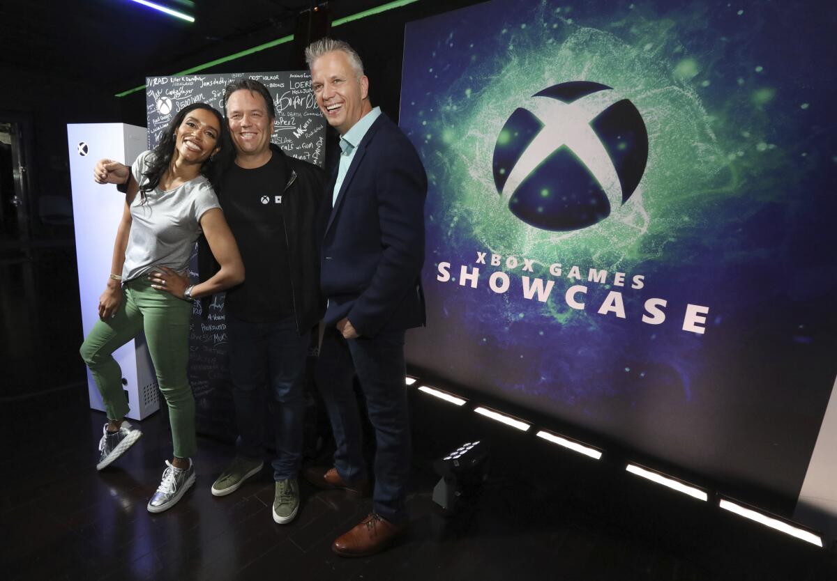 IMAGE DISTRIBUTED FOR XBOX - Sarah Bond, from left, CVP Game Creator Ecosystem, Phil Spencer, Head of Xbox, and Matt Booty, CVP Xbox Game Studios, pose during the 2023 Xbox FanFest on Sunday, June 11, 2023 in Los Angeles. (Casey Rodgers/AP Images for Xbox)