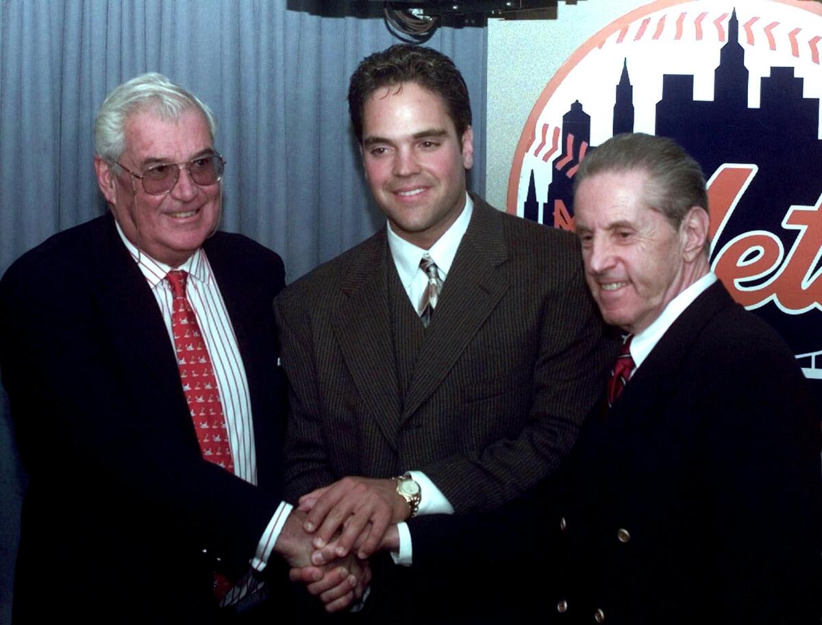 New York Mets catcher Mike Piazza, center, smiles with Mets owners Nelson Doubleday Jr., left, and Fred Wilpon after a news conference about Piazza's contract with the Mets in this 1998 file photo. Doubleday died on Wednesday.