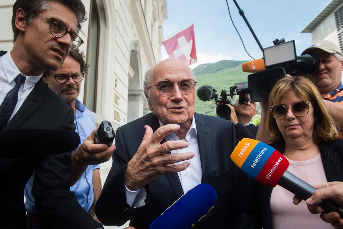 Former FIFA president Sepp Blatter is surrounded by the media as he leaves the Swiss Federal Criminal Court in Bellinzona, Switzerland, Wednesday, June 8, 2022. Blatter and former UEFA president Michel Platini have arrived at a Swiss criminal court for their 11-day trial on charges of defrauding FIFA, the world governing body of soccer. (Alessandro Crinari/Keystone via AP)