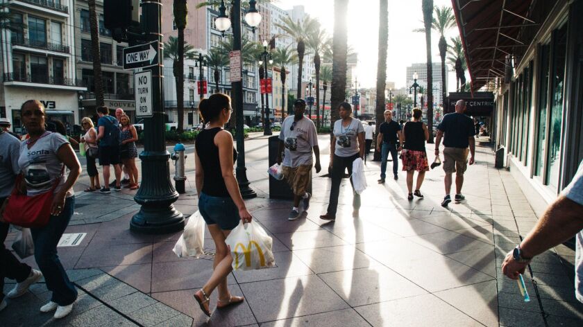 Shoppers and pedestrians walk along Canal Street in New Orleans on June 13, 2018. Tariffs on foreign imports could make inflation soar — and could pass price increases along to consumers.