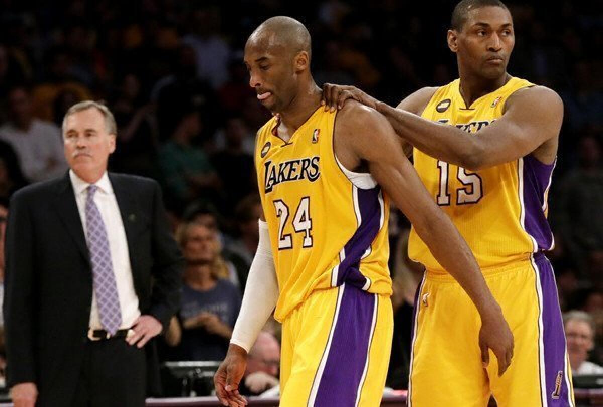 Lakers forward Metta World Peaces gives guard Kobe Bryant a pat on the back as he limps off the court after he made two free throws following a foul and Achilles' tendon injury Friday night.