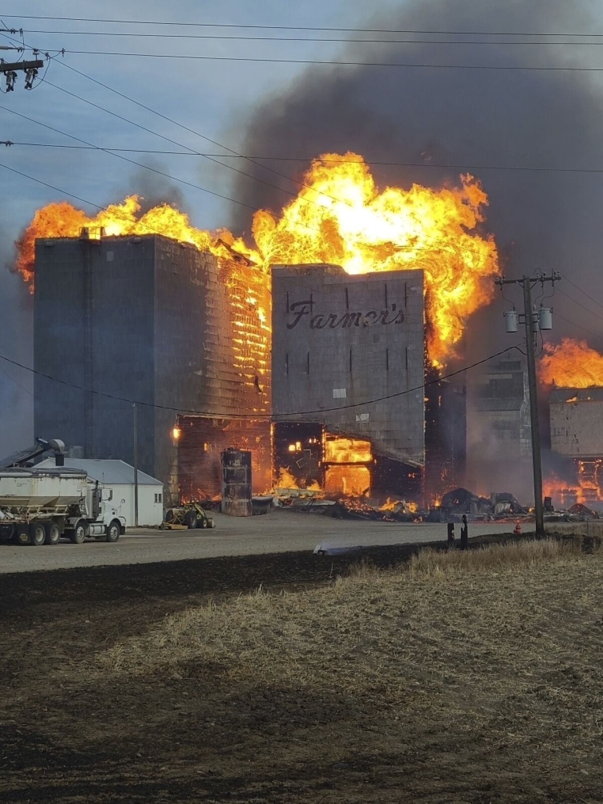 This photo provided by the Fergus County Sheriff's Office shows a grain elevator burning in the central Montana town of Denton on Wednesday, Dec. 1, 2021. A late-season wildfire pushed by strong winds ripped through the tiny central Montana farming community burning two dozen homes and four grain elevators. About 300 residents were evacuated early Wednesday afternoon and the evacuation orders were lifted Thursday. (Fergus County Sheriff's Office via AP)